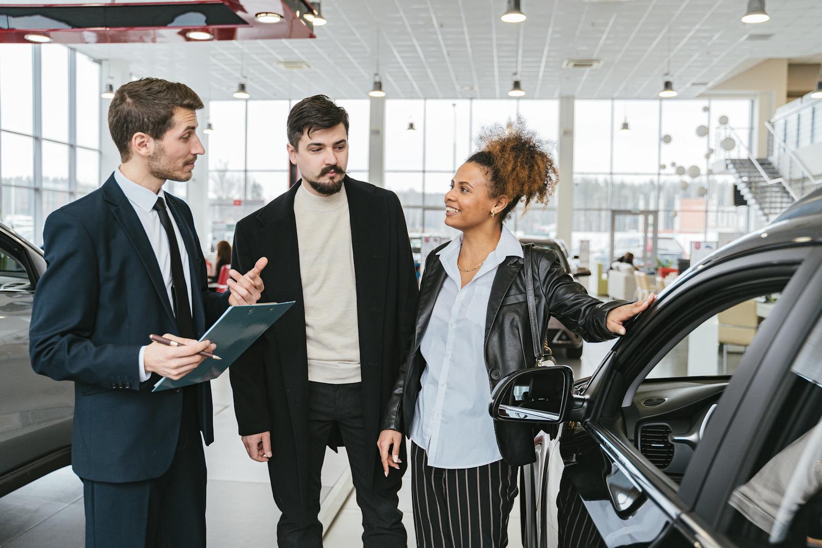 Man in Blue Business Suit Talking to Woman Touching the Car, Auto Insurance